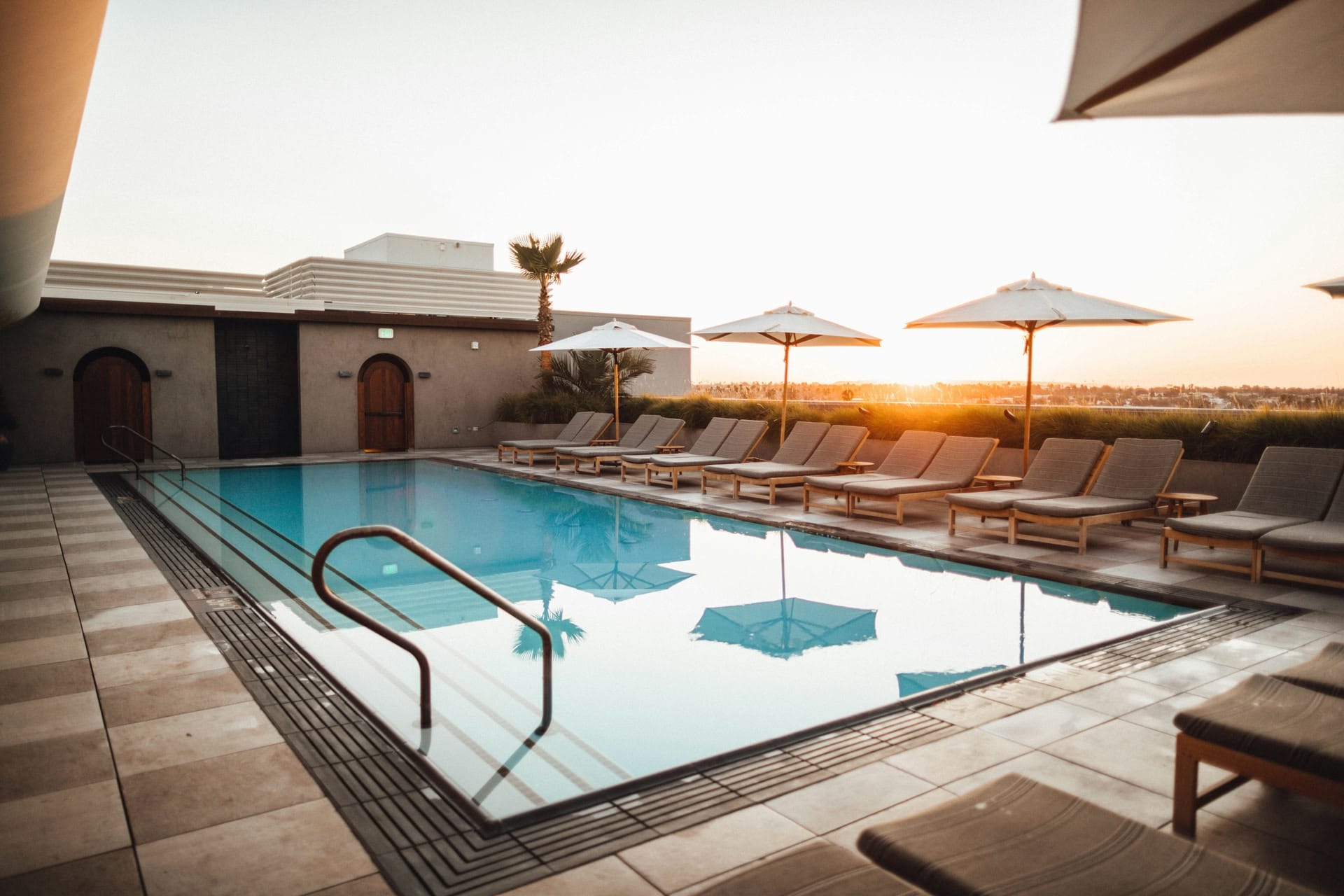Piscine rectangulaire en pierre claire dans un jardin clos